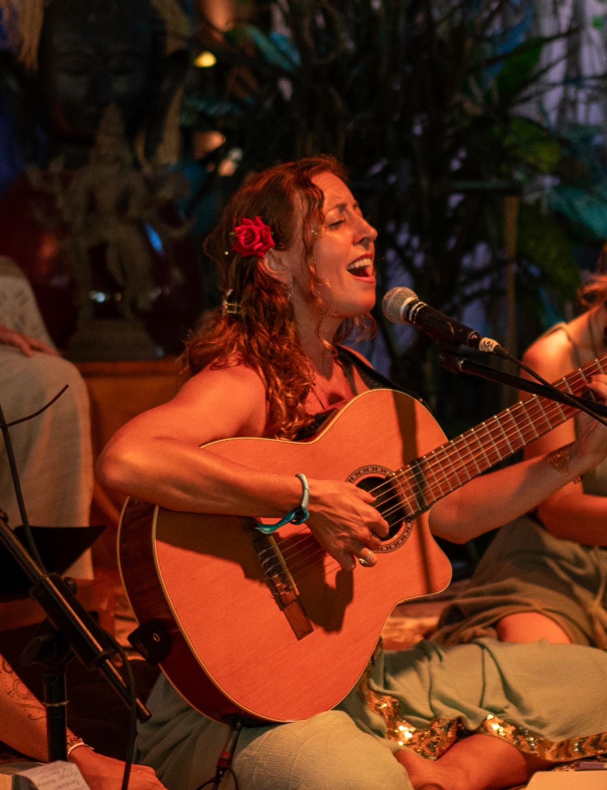 Francie singing with her guitar, a rose in her hair