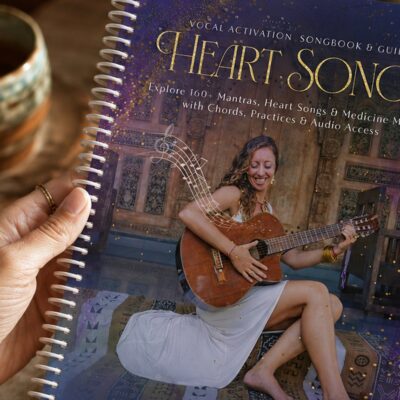 The HeartSongs Vocal Activation Songbook held in both hands by candlelight