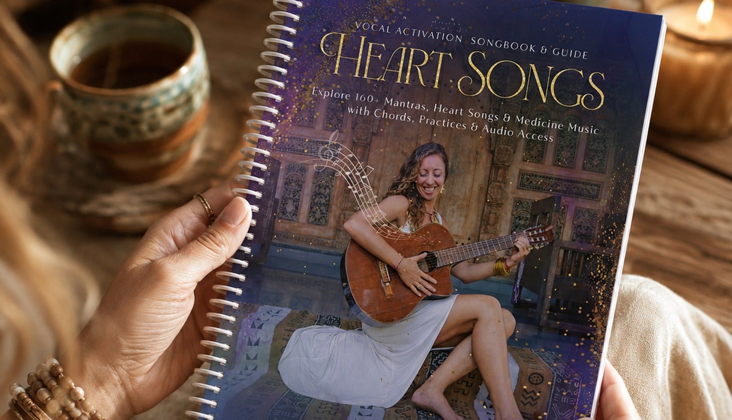The HeartSongs Vocal Activation Songbook held in both hands by candlelight