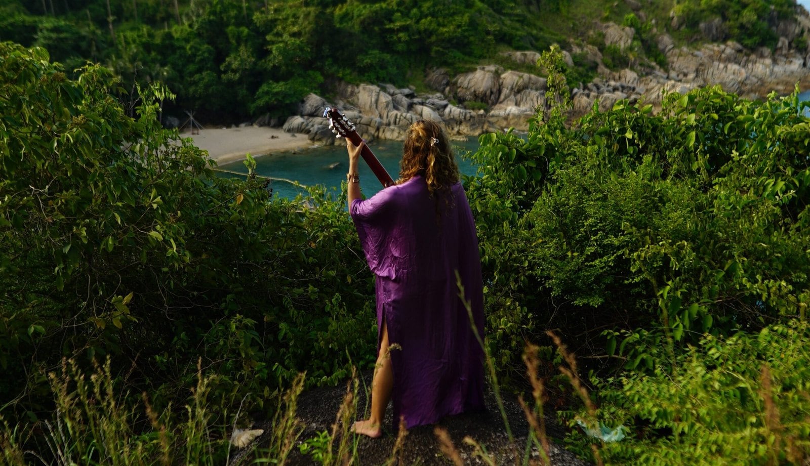 Francie in a purple dress on a headland above the bay