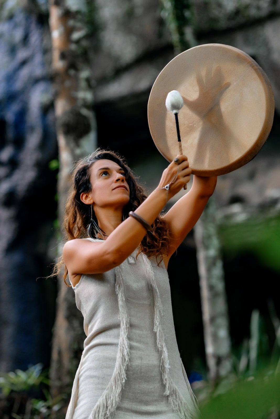Marlia Coeur raising a frame drum in ceremony