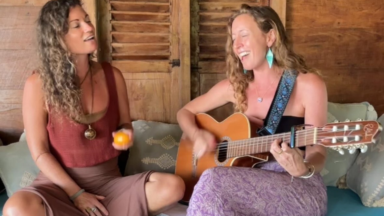 Francie and Elizabeth Anura singing together with a guitar in Bali