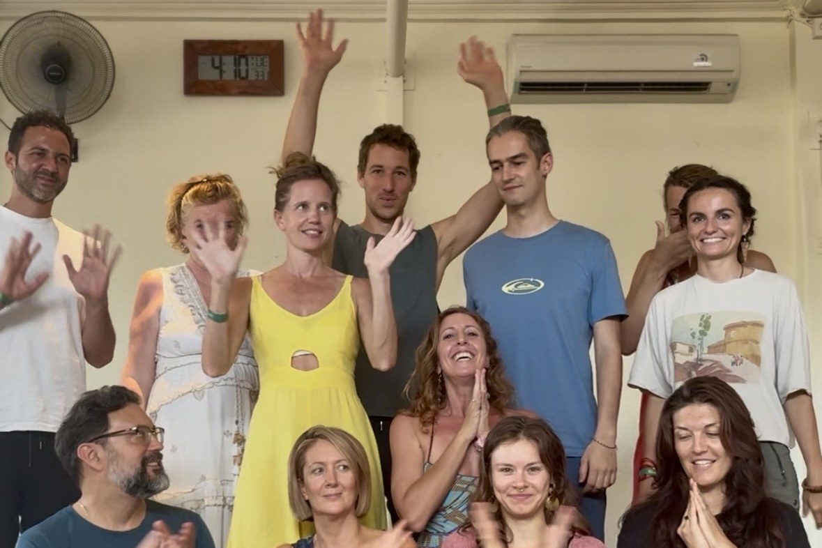 An Awaken Your Voice workshop group with their hands raised